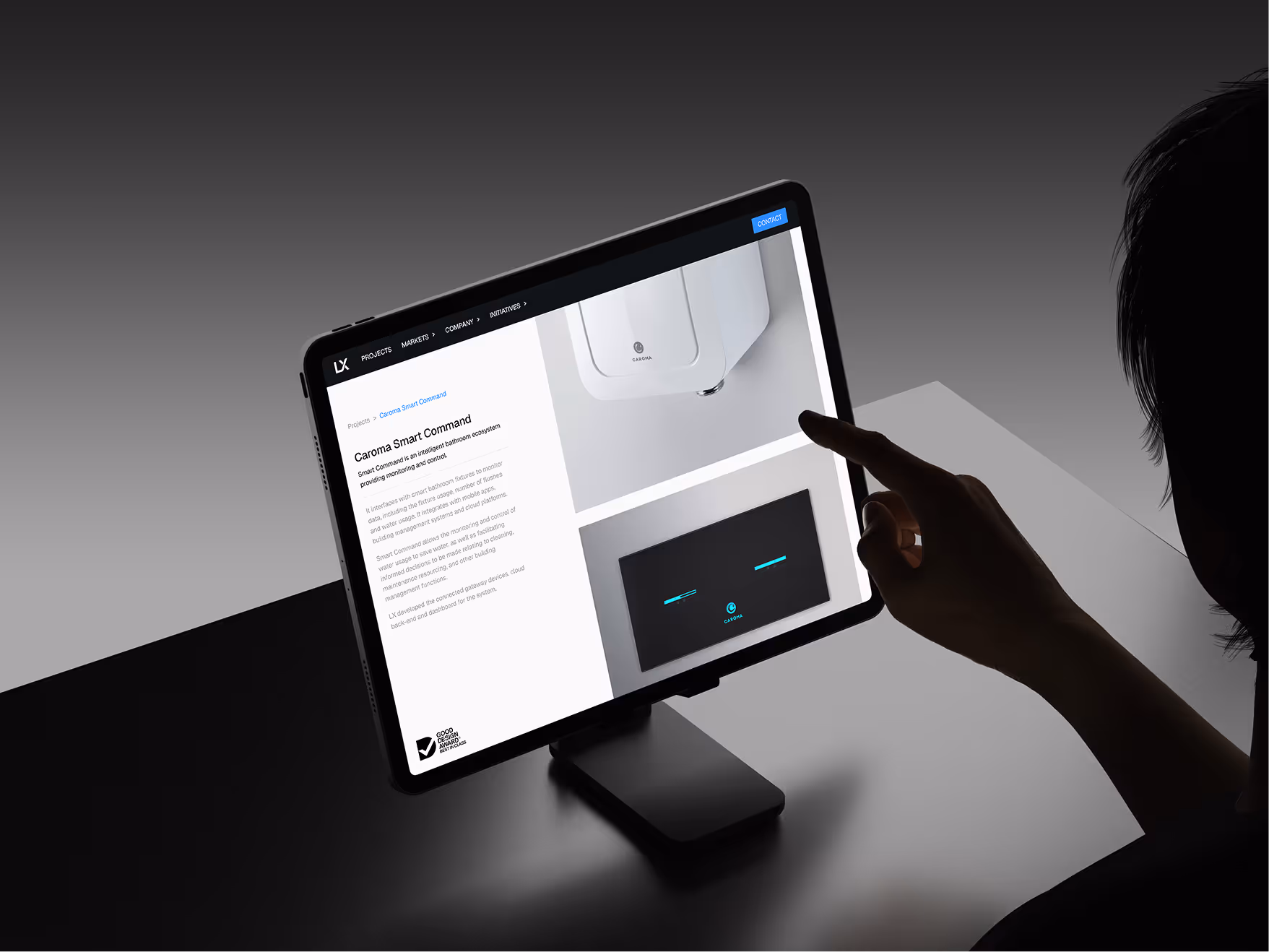 Person interacting with a digital tablet displaying the Caroma Smart Command bathroom monitoring system webpage.